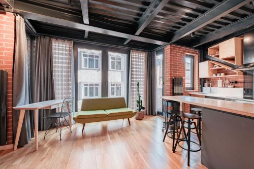 伊斯坦布尔Homie Suites - Loft 27 in the heart of Cihangir的厨房以及带沙发和台面的客厅。