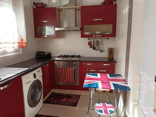 阿尔及尔La crique的一间带红色橱柜和洗衣机的厨房
