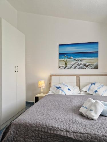 特罗吉尔Apartments Silva的卧室配有一张床,墙上挂有绘画作品