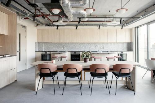 都柏林Niche Living - Dun Laoghaire的厨房配有带粉红色椅子的大桌子