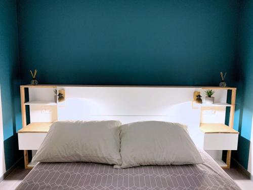 鲁昂Eco-Appart'hôtel Rouen -- JDP的卧室内的一张床铺,卧室内有蓝色的墙壁
