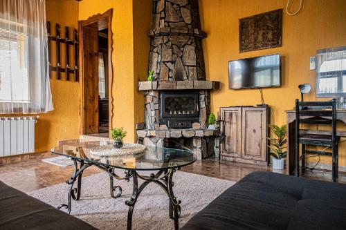 韦林格勒Safari Village Velingrad的客厅配有桌子和石头壁炉