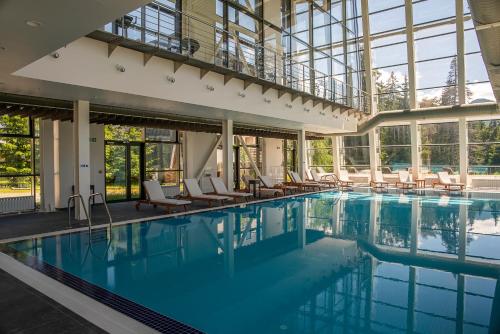 波罗维茨尤弗里亚俱乐部酒店的一个带椅子和窗户的大型游泳池