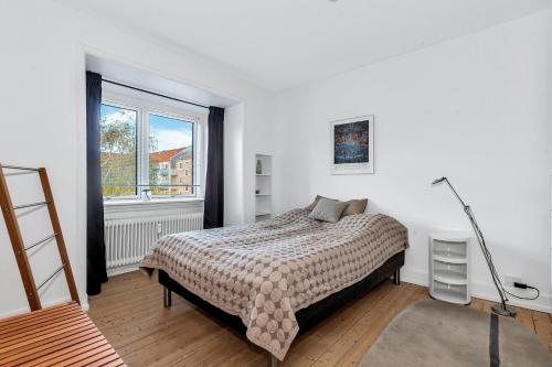 奥尔堡Plads til 4 personer - 5 minutter fra Friluftsbadet的一间卧室设有一张床和一个窗口
