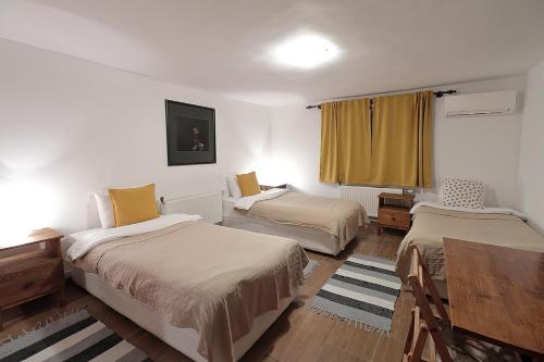 MadzharovoVulture Centre Eastern Rhodopes的客房设有两张床、一张桌子和一扇窗户。