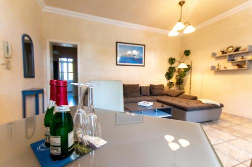 奥斯赛拜-塞林Villa Bertha的客厅配有一张桌子和两瓶葡萄酒