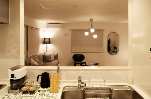 东京6 mins to walk JR Okubo station 1stop to Shinjuku BRAND NEW silent stylish 3BR villa的一个带水槽的厨房和一间客厅