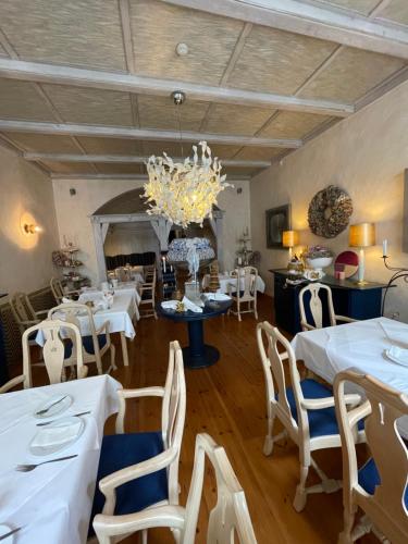 施特拉尔松德豪斯沃弗卡纳酒店的一间配备有白色桌椅和吊灯的餐厅
