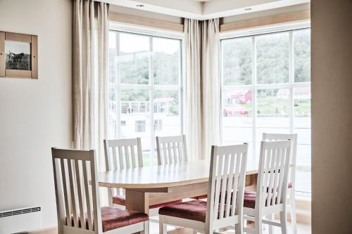 法尔松Farsund Resort的餐桌、四把椅子和窗户