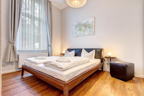 赛巴特班森Villa Anna Wohnung Bernstein的一间卧室配有一张带白色床单的床和一扇窗户。