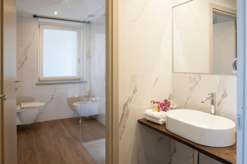 阿尔巴CASCINA SANT'ANTONIO的白色的浴室设有水槽和镜子