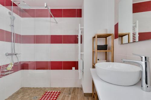莱萨布勒-多洛讷Detente et evasion aux Sables dOlonnes的浴室设有白色水槽和红色及白色瓷砖