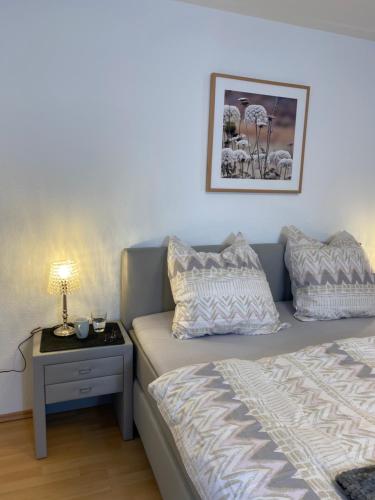 兰河畔马尔堡Apartment Lahnblick的一间卧室配有一张床和一个带台灯的边桌
