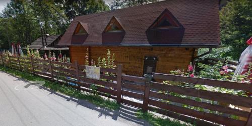 利波瓦Domek w Dolinie Zimnika的一座带木栅栏和鲜花的小房子