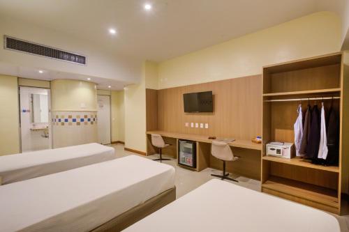 里约热内卢Rio Aeroporto Hotel Galeão的酒店客房配有两张床和一张书桌