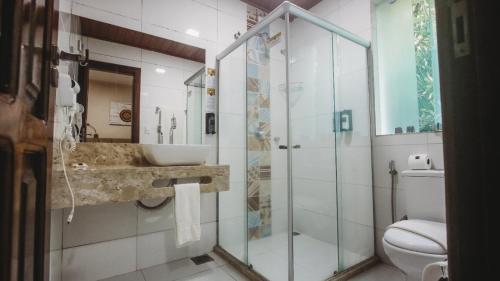 莫罗圣保罗Pousada Safira do Morro的带淋浴、盥洗盆和卫生间的浴室