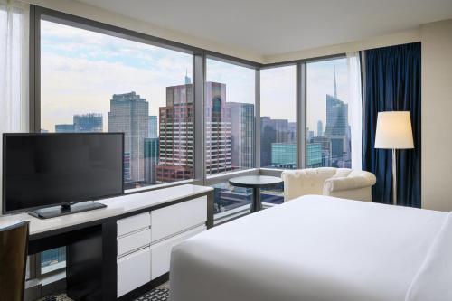 纽约纽约曼哈顿/中央公园万豪居住酒店的酒店客房设有一张床和一个大窗户
