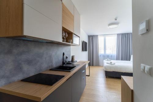弗罗茨瓦夫Milo Aparthotel的一个带水槽的厨房和一张位于客房内的床