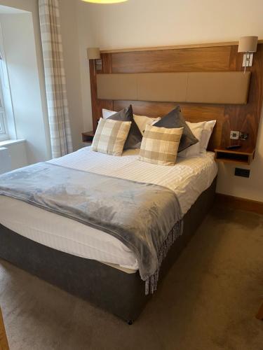 皮特洛赫里Garden Rooms Ferry Rd Pitlochry的一间卧室配有一张大床和木制床头板