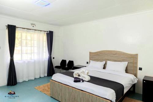 纳纽基Riverside Villas Nanyuki的一间卧室设有一张大床和一个窗户。