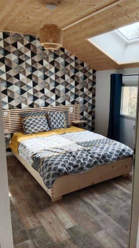 La Chaux-du-DombiefGîte des Roches的一间卧室配有一张带 ⁇ 形墙的床