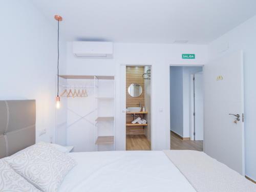 托雷德本纳贾尔邦Cubo's Hostal William's Sunny 3 with Breakfast的卧室配有白色的床和衣柜。