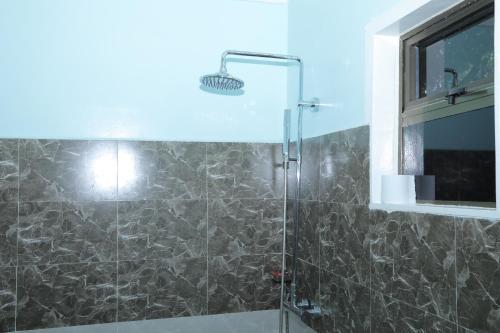 纳纽基Riverside Villas Nanyuki的带淋浴的浴室和玻璃门