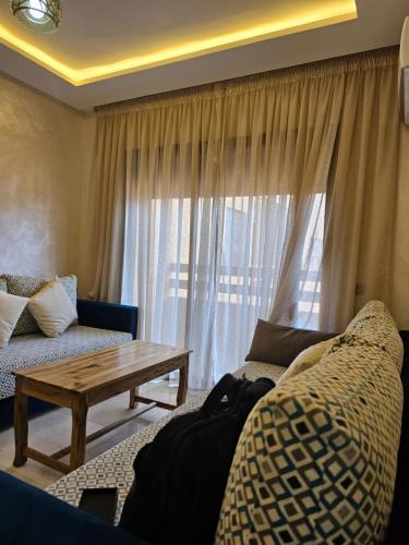 马拉喀什Appartement de rêve 2的带沙发、桌子和窗户的客厅