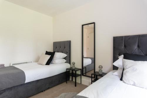 克劳利Spacious, Modern, Fully Furnished Apartment - 2 FREE PARKING Spaces - 8 min LGW Airport的一间卧室配有两张床和镜子