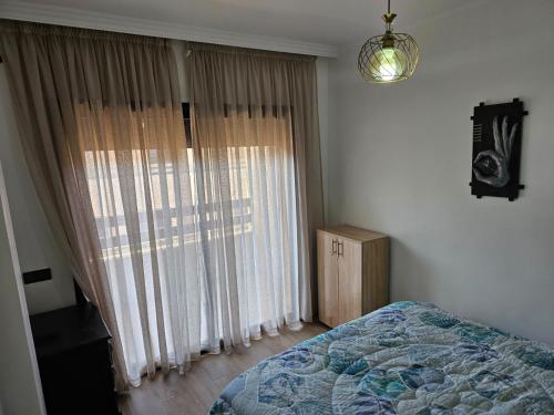 马拉喀什Appartement de rêve 2的一间卧室设有一张床和一个大窗户