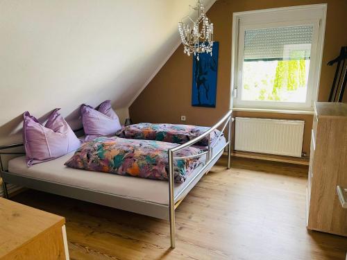GriffenAPARTMENT Schlossbergblick的一间卧室配有一张带紫色枕头和吊灯的床。