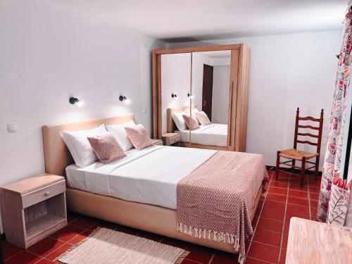 丰沙尔金塔梅多斯霍蒙斯酒店的一间卧室配有一张大床和镜子