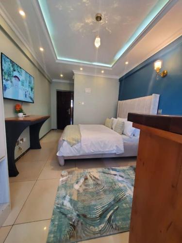 内罗毕Cozy Studio Stay Kilimani Valley Acarde Area的一间酒店客房,配有一张床和一台电视