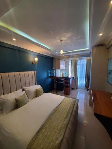 内罗毕Cozy Studio Stay Kilimani Valley Acarde Area的卧室配有一张白色大床和一张书桌