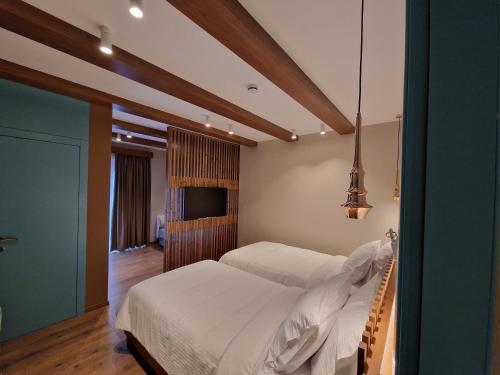 吉诺卡斯特Palorto Hotel的一间卧室配有两张床和一台平面电视