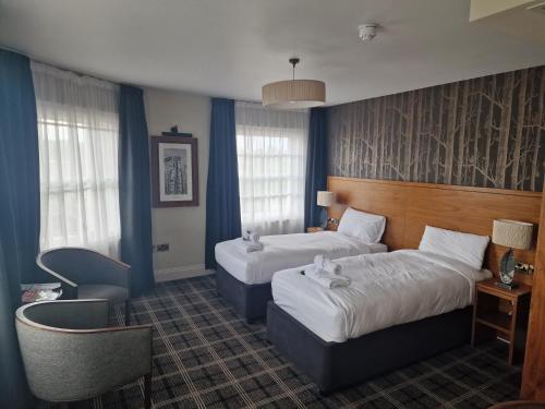 奥尔德肖特维特斯普恩女王酒店的酒店客房,配有两张床和椅子
