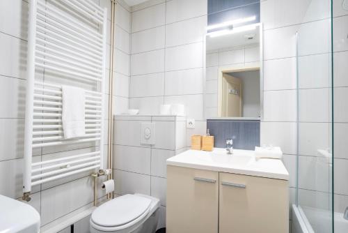 希尔蒂盖姆Le Fournil - WiFi - Séjournez à proximité de tout的白色的浴室设有卫生间和水槽。