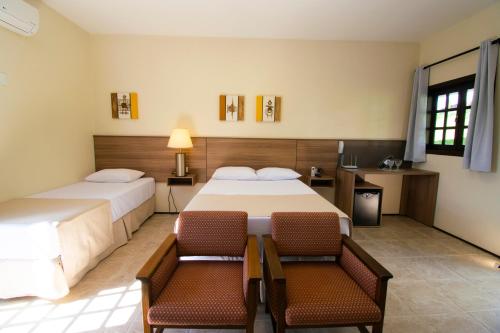 索科罗Hotel Dona Paschoalina的酒店客房,配有两张床和两把椅子