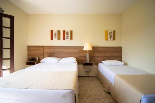 索科罗Hotel Dona Paschoalina的酒店客房,设有两张床和一盏灯