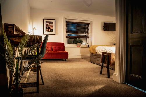埃文河畔斯特拉特福Caffeine&Machine的客厅配有红色的沙发和床。