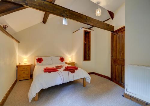 Bratton FlemingButton Barn的卧室配有一张白色大床和红色毛巾