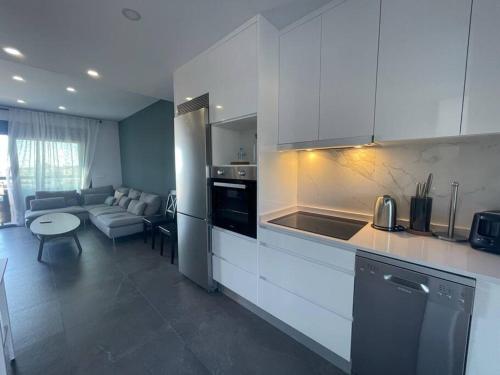 马萨龙New built 3-bed penthouse with pool, Mar de Plata的一间带白色橱柜的厨房和一间客厅