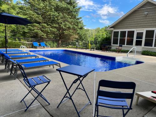 WashingtonOld Litchfield, Washington CT的一组椅子和桌子,位于游泳池旁