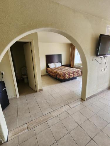 梅斯基特HomeTown Inn and Suites的一间卧室配有一张床,拱门配有电视