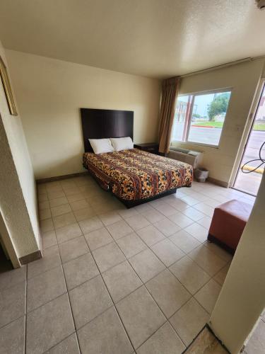 梅斯基特HomeTown Inn and Suites的酒店客房设有一张床和一个大窗户