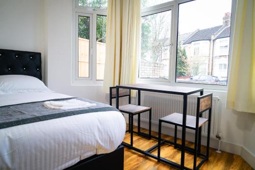 伦敦Centra Studios的一间卧室配有一张床、一张桌子和一个窗户。