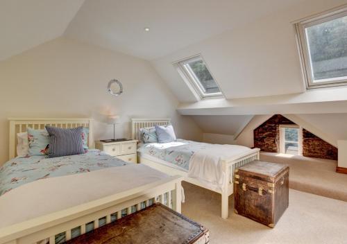 林茅斯River Cottage的阁楼间设有两张床和两扇窗户