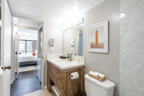 檀香山Stunning Skyview, Pool, Fabulous Location!的白色的浴室设有水槽和卫生间。