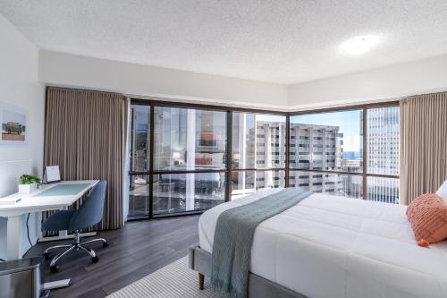 檀香山Stunning Skyview, Pool, Fabulous Location!的配有一张床、一张书桌和一扇窗户的酒店客房