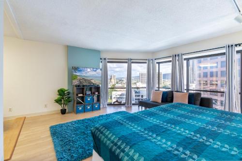 檀香山Spacious Downtown Executive Retreat - Free Parking的一间卧室配有一张蓝色的大床和一张沙发